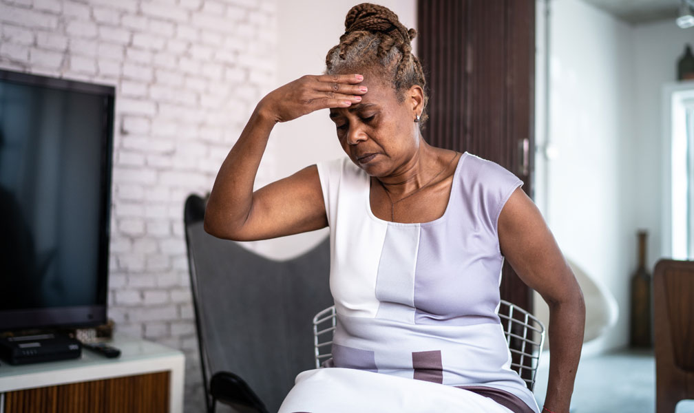 Forlorn senior female with head resting on hand